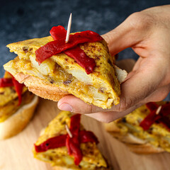 Wall Mural - Spanish tortilla pintxo on a wooden board. Potato omelette on bread as a basque canape on sharing board. Party food. 