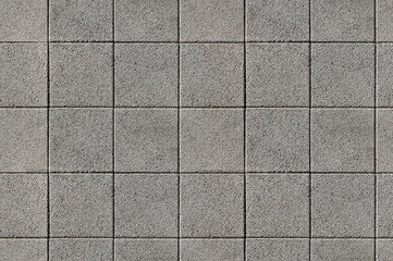 Coating with modern textured paving tiles of square shape.