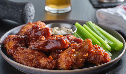 boneless chicken wings covered in honey garlic bbq sauce with ranch and celery