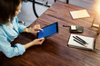 © Rymden - Mockup image of a woman using digital tablet with blank screen on wooden table. Close up photo of female hands holding device vertically