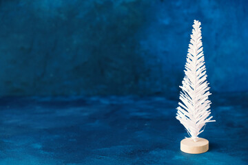 Wall Mural - White Christmas tree decoration on blue texture background.