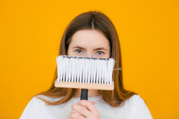 Wall Mural - Young female decorator with paint roller on yellow background