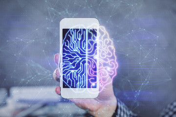 Double exposure of man's hand holding and using a digital device and brain hologram drawing. Data concept.