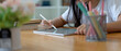 © bongkarn - Girl relaxing with mock-up digital tablet on wooden worktable after finish her homework