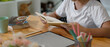 © bongkarn - Girl doing homework with mock-up tablet and stationery on wooden desk in living room