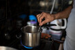 © abir - Tea being prepared in a steel tea pot in an Indian kitchen. Indian drink and beverages.