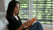 © bongkarn - Female freelancer looking on her schedule book while sitting on floor at bedroom