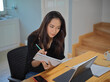 © bongkarn - Female university student online studying with digital tablet and stationery