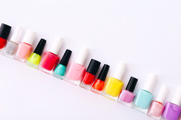 Wall Mural - Group of nail polishes of different colors on white background