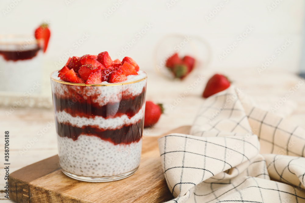 Tasty strawberry dessert in glass on table
