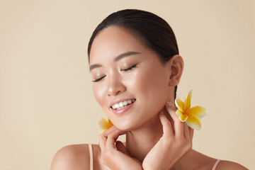 Wall Mural - woman and flowers beauty portrait. beautiful ethnic girl with perfect glowing and hydrated facial sk