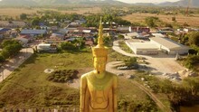 Close Up Aerial View Of Big Golden Buddha Statue With A Coutryside Background, Thailand
