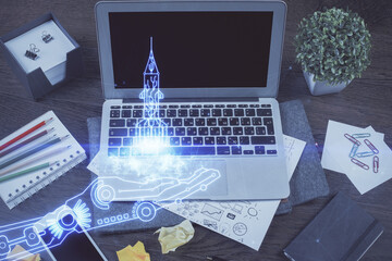 Desktop computer background in office and start up theme hologram drawing. Double exposure. Startup concept.