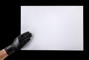 Wall Mural - Hand in black gloves holding blank cardboard isolated on black