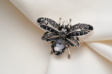 Silver brooch shaped like a beetle, insect, bee , with small diamonds, isolated on white background