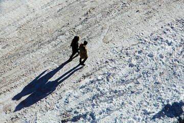 two persons walking on the snow street