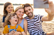 © pikselstock - Family taking self portrait on beach