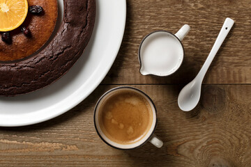 A double doughnut, coffee and milk on a wooden table.