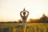 Young woman practicing yoga on nature.