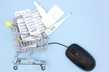 Medicines in shopping cart in drugstore with mouse to online order on blue background. Online Pharmacy. Buying Medicine. idea for health insurance.