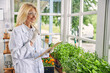 © Svitlana - Beautiful happy biologist standing among the seedlings