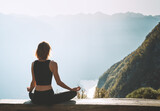 Fototapeta  - Young woman is meditating in mountains.