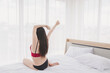 © Chatchai - Asian people are beautiful, charming Stretching in the morning on the bed in a white bedroom.