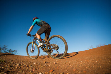 Wide angle view of a mountain biker speeding downhill on a mountain bike track.