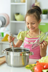 Wall Mural - Portrait of cute girl cooking on kitchen