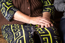 Hands Of An Elderly Woman In A Knitted Sweater And Bathrobe, On Her Lap. Horizontal Orientation.