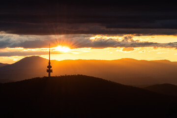 Wall Mural - Sunset over Canberra's tower with layers of clouds and hills in the background