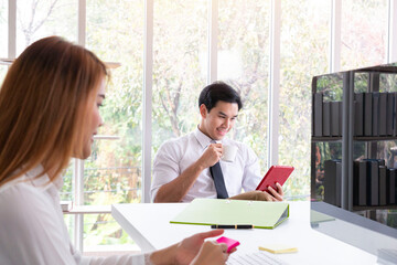 Happy confident young businessman using a tablet while working in modern office. Happy businessman in modern office using tablet. Smiling cheerful entrepreneur in casual office. Office manager.