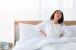 © Avirut S. - Young girl stretching in bed after wake up. Portrait of beautiful asian woman enjoying fresh soft bed linen mattress in bedroom. Woman Stretching in Her Bed. A Girl waking up in the Morning on bed.
