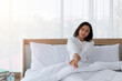© Avirut S. - Young girl stretching in bed after wake up. Portrait of beautiful asian woman enjoying fresh soft bed linen mattress in bedroom. Woman Stretching in Her Bed. A Girl waking up in the Morning on bed.