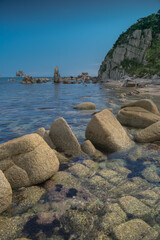 Poster - Sea shore with transparent water and stones at the bottom. seascape with rugged islands and boulders peeping out of the water