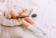 © ASTA Concept - Young woman on the bed with old book and cup of coffee enjoys her stay.