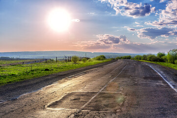 Bright sun over an asphalt road