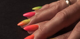 Fototapeta  - Kolorowe paznokcie przedstawione z bardzo bliska, na ciemnym tle