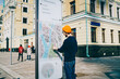 © BullRun - Young male traveler using modern smart board with map and useful information for tourists, caucasian hipster guy searching train on electronic device on street with wifi connection and touchscreen .