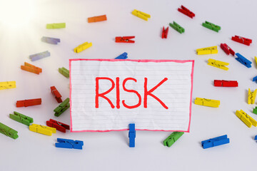 Wall Mural - Conceptual hand writing showing Risk. Concept meaning implies future uncertainty about deviation from expected earnings Colored clothespin papers empty reminder white floor office