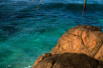 View from above to the brown big rock and blue ocean aquamarine colour in tropical island.