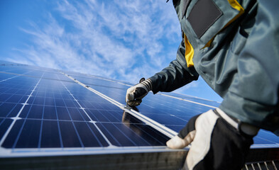 close up of man technician in work gloves installing stand-alone photovoltaic solar panel system und