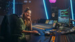 Stylish, Beautiful Female Audio Engineer Working in Music Recording Studio, Uses Mixing Board Create Song. Looking at Camera Portrait of a Girl Artist Musician Working at Control Desk and Smiling