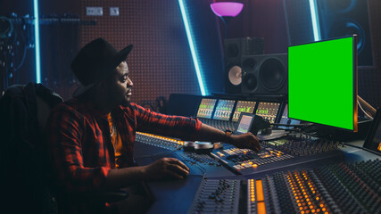Poster - Stylish Audio Engineer Producer Working in Music Record Studio, Uses Green Screen Computer, Mixer Board Equalizer and Control Desk to Create New Hit Track and Song. Artist Musician. Side View Portrait