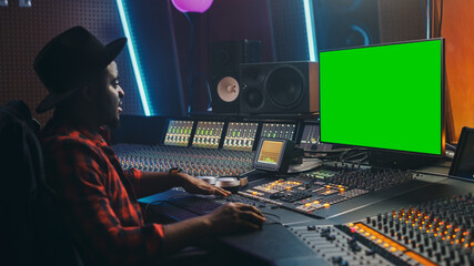 Poster - Stylish Audio Producer Working in Music Record Studio, Uses Green Screen PC, Mixer Board Equalizer and Control Desk to Create New Hit Track and Song. Creative Black Artist Musician. Side View Portrait