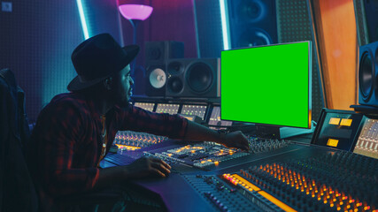 Poster - Stylish Audio Producer Working in Music Record Studio, Uses Green Screen Chroma key Computer Display, Mixer Board Equalizer and Control Desk to Create New Hit Song. Creative Black Artist Musician