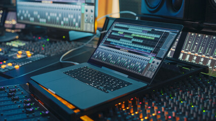 Fototapete - Modern Music Record Studio Control Desk with Laptop Screen Showing User Interface of Digital Audio Workstation Software. Equalizer, Mixer and Professional Equipment. Faders, Sliders. Record. Close-up 