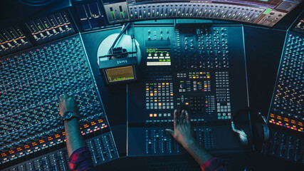 Fototapete - Audio Engineer, Musician, Artist Works in the Music Record Studio, Control Desk Mixer with Equalizer. Hand Moving Fader, Buttons to Broadcast, Record, Play Song. Neon Colors. Top Down View