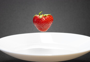 strawberry close-up /floating strawberry over a plate