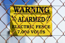 Yellow Warning Sign On Electric Fence